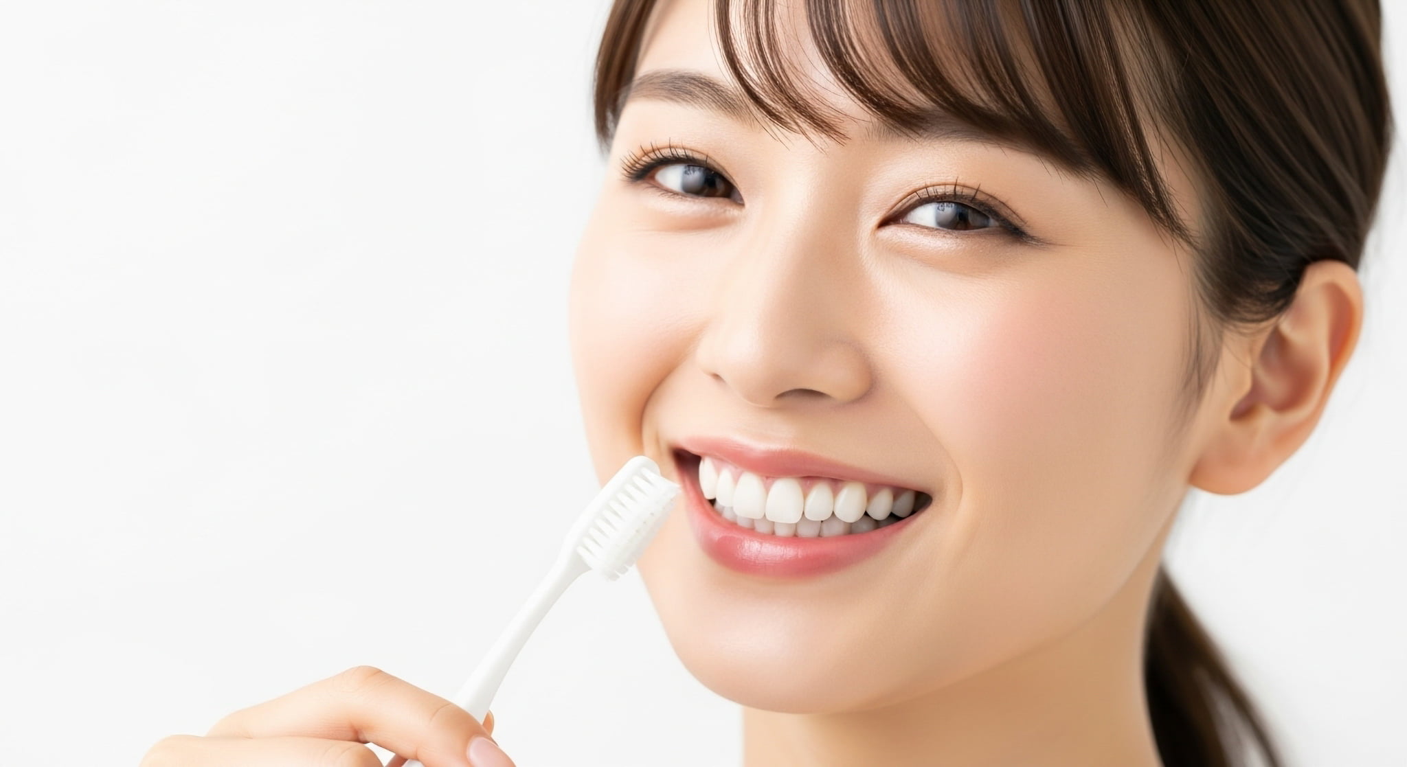 歯ブラシを手に笑顔を見せる女性