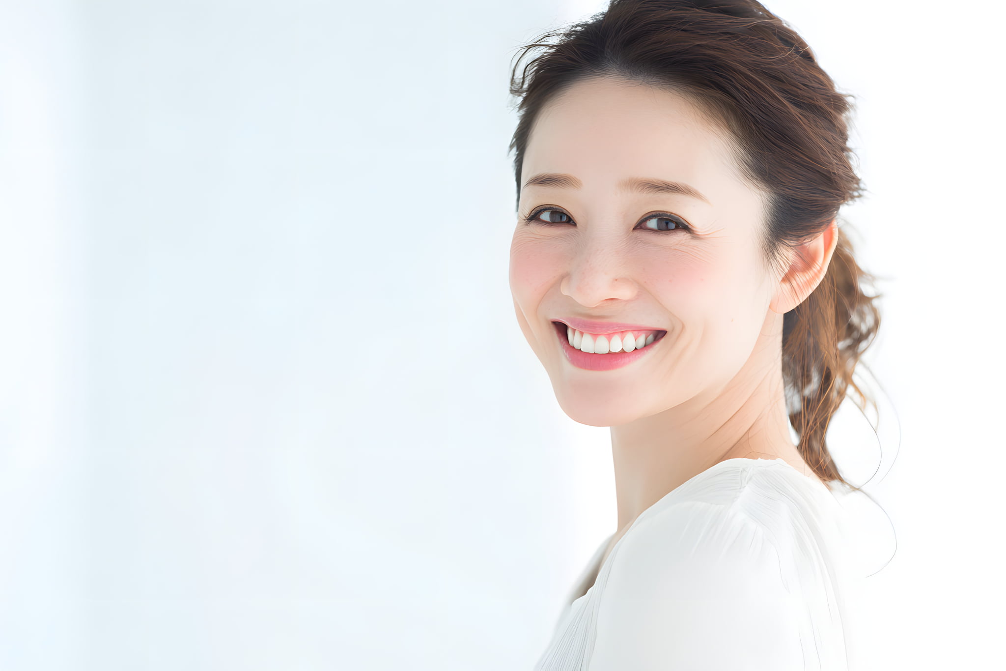 白い歯になって笑顔を見せる女性