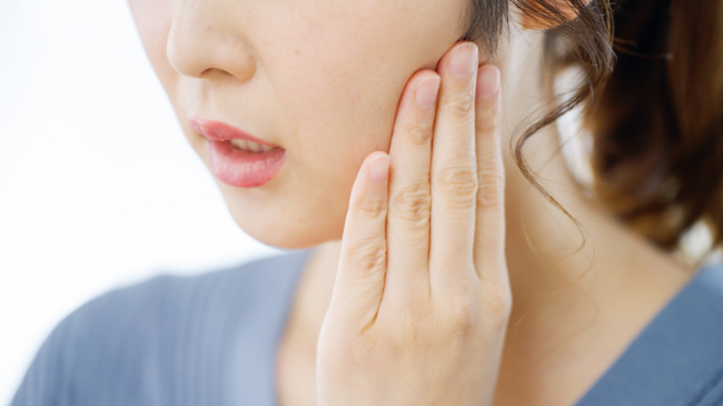 歯ぎしりで歯が痛む女性