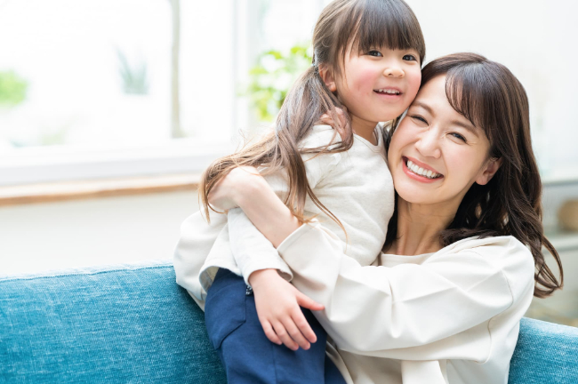 子どもを抱っこする母親と嬉しそうな子ども