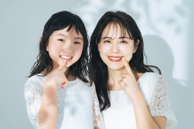 きれいな歯並びを指さす親子