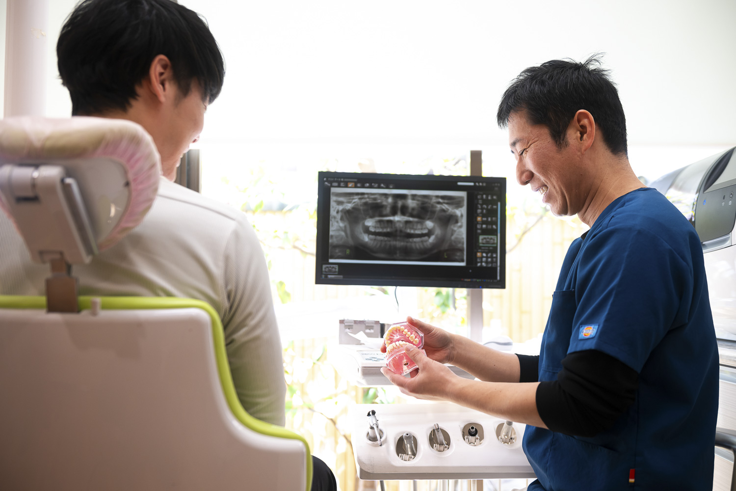 患者さまにレントゲン画像を見ながら説明する院長